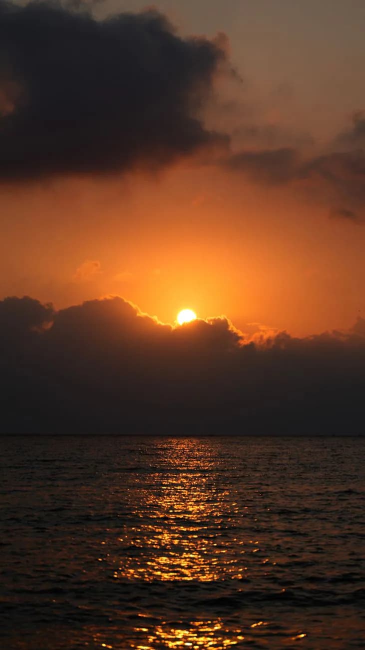 Sunlight emerging over the ocean horizon