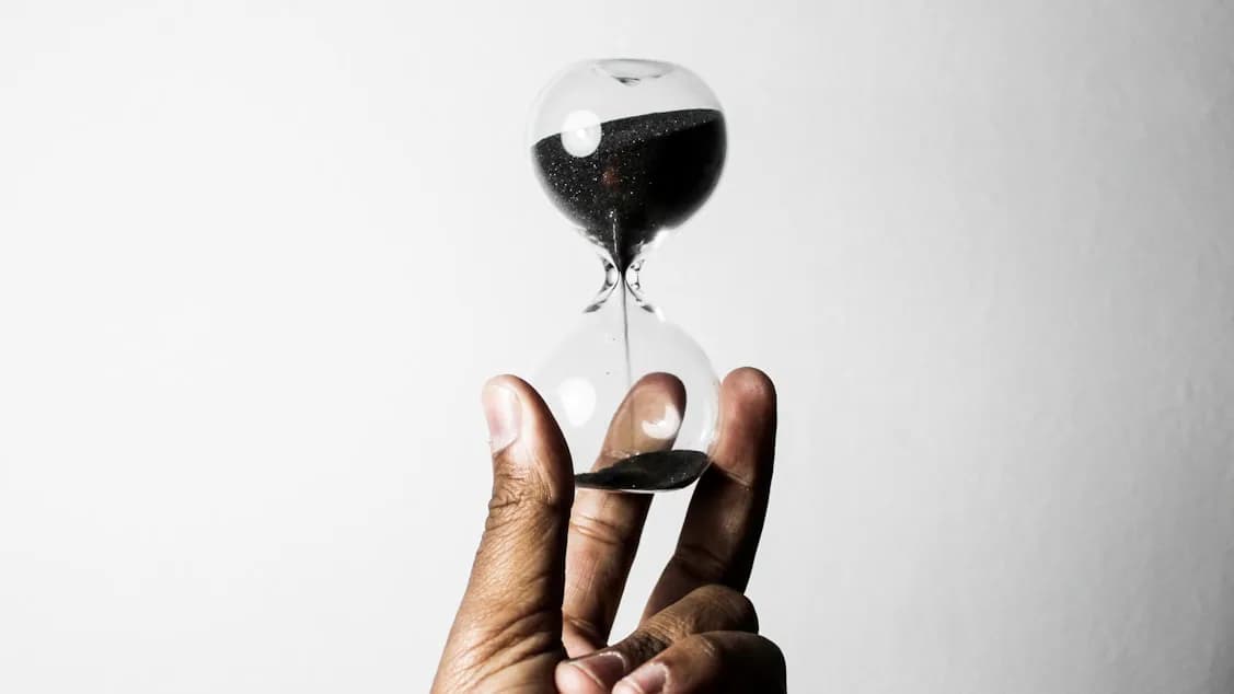 A person holding an hourglass representing timing intelligence
